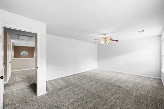 a view of a big room with closet and a chandelier fan