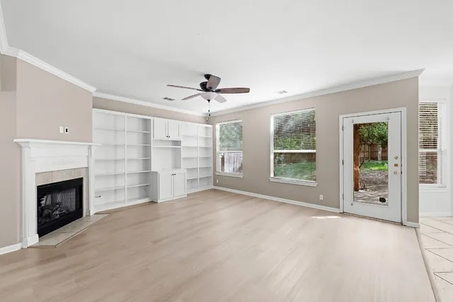 a view of an empty room with a fireplace and a window