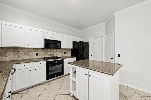 a kitchen with stainless steel appliances granite countertop a sink and dishwasher a stove top oven with white cabinets