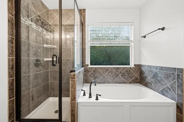 a bathroom with a bathtub and shower