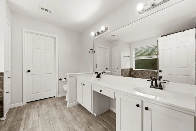 a bathroom with a double vanity sink mirror and