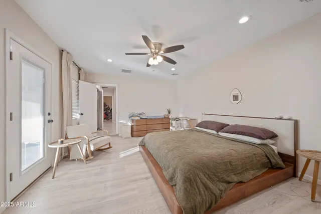 a spacious bedroom with a bed and ceiling fan