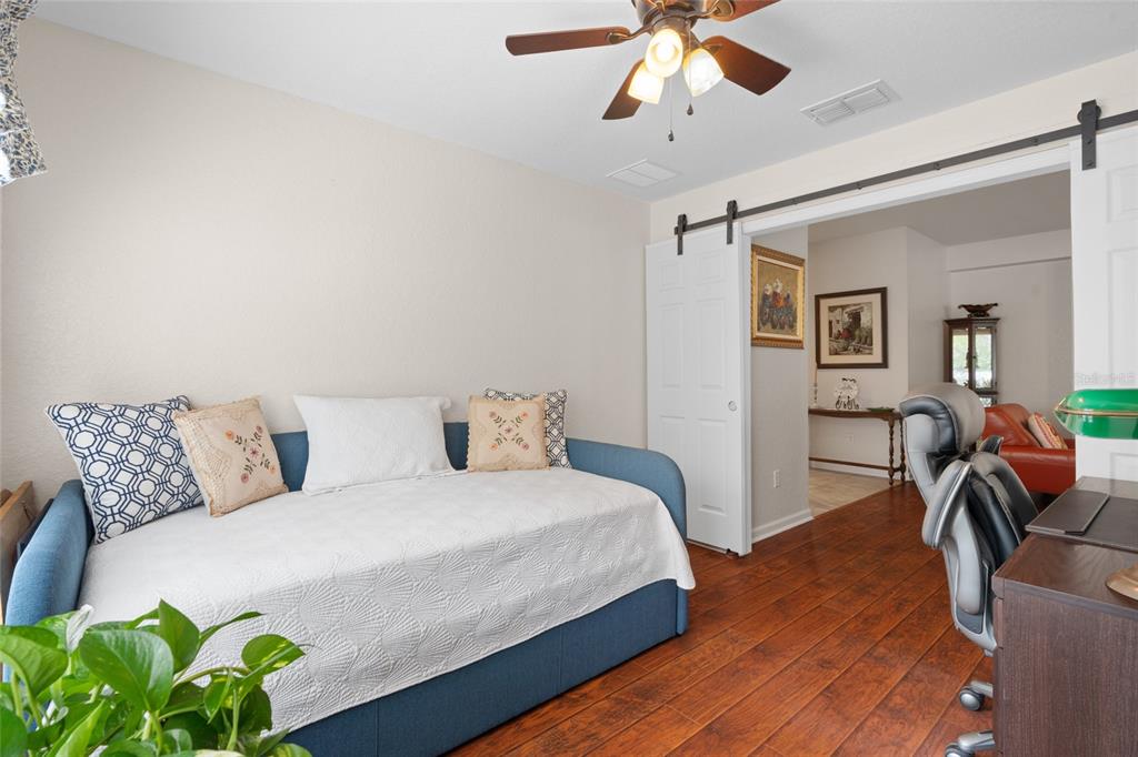 4683 Southwest 40th Place Ocala, FL 34474 - Photo 16 of 43 a bedroom with a bed and a chandelier