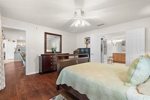 a large bedroom with wooden floor and furniture