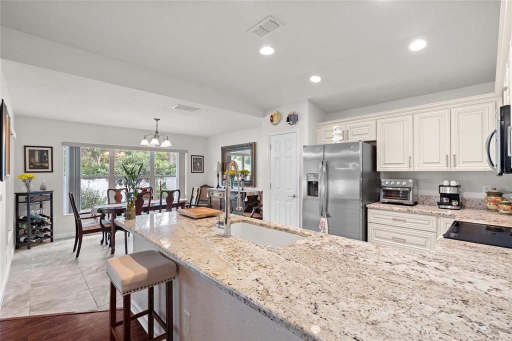 4683 Southwest 40th Place Ocala, FL 34474 - Photo 2 of 43 a kitchen with sink refrigerator dining table and chairs