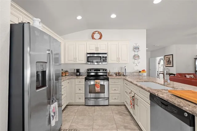 a kitchen with stainless steel appliances granite countertop a refrigerator stove and sink