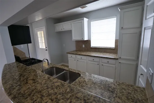 a kitchen with a sink cabinets and a window