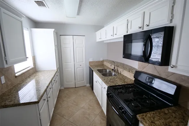 a kitchen with granite countertop a stove and a sink