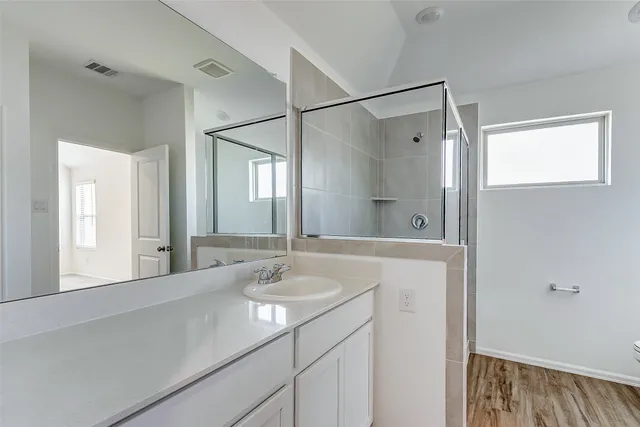 a bathroom with a shower sink and mirror