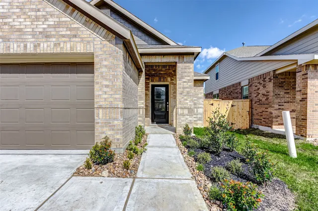 a stone house with flower garden in front of it