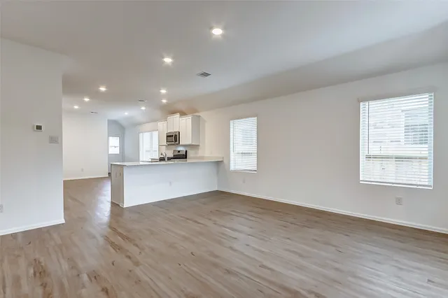 a view of kitchen with kitchen island white cabinets and wooden floor