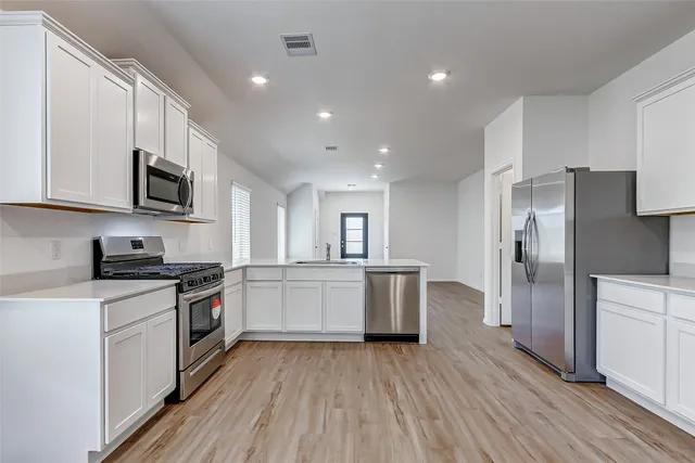 a kitchen with a refrigerator stove top oven and sink