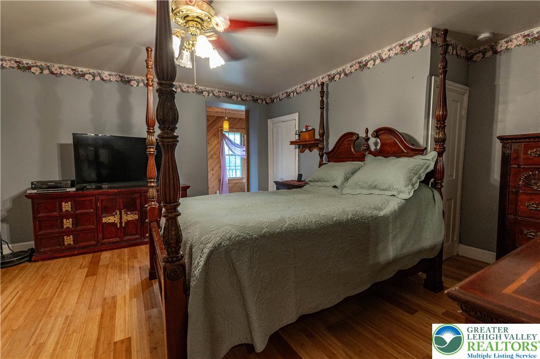 2485 Hieter Road Quakertown, PA 18951 - Photo 29 of 97 Hardwood floors and a detailed four-poster bed create a warm, inviting sleeping area.
