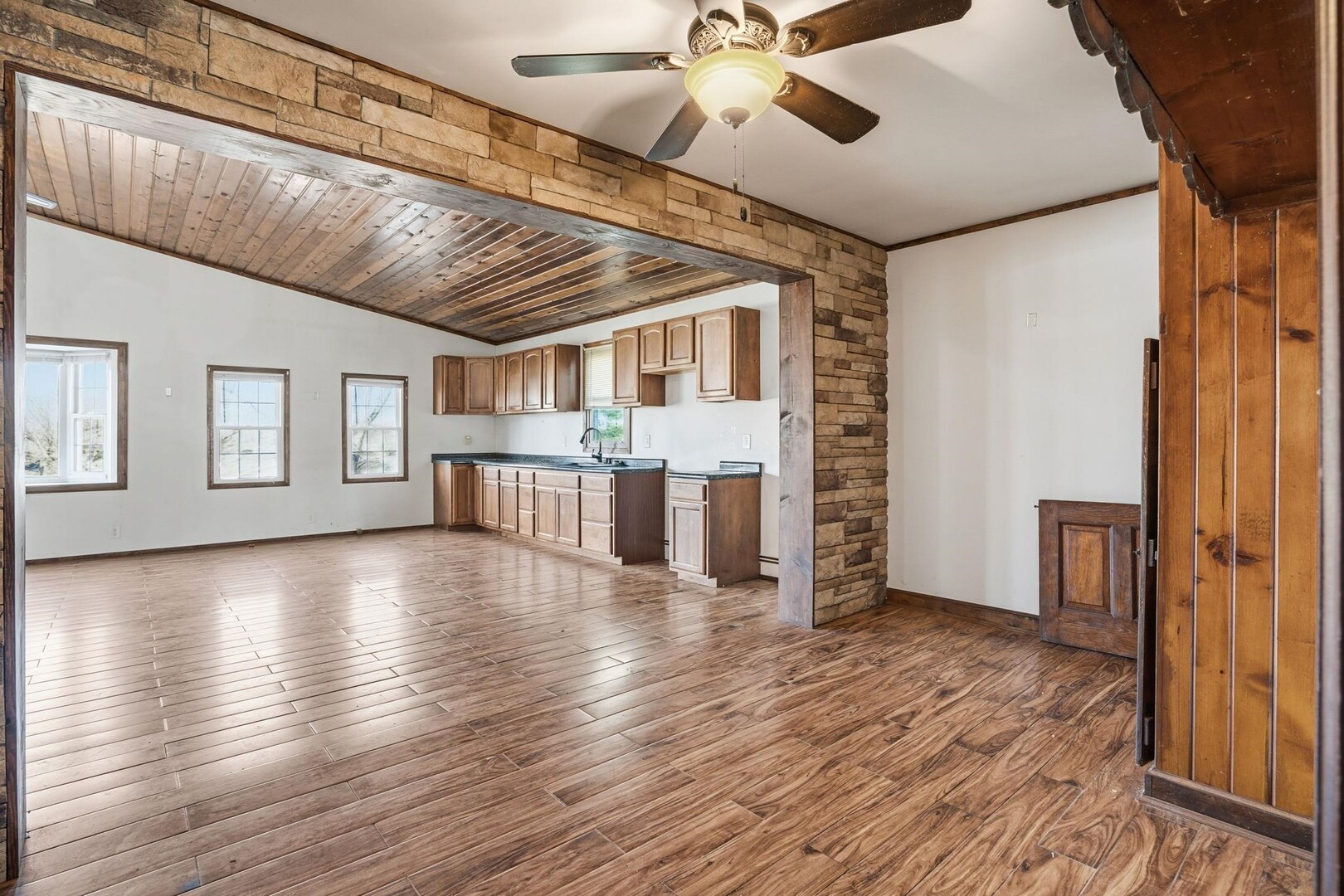5029 69th Avenue Milan, IL 61264 - Photo 5 of 25 a view of a livingroom with wooden floor and a ceiling fan