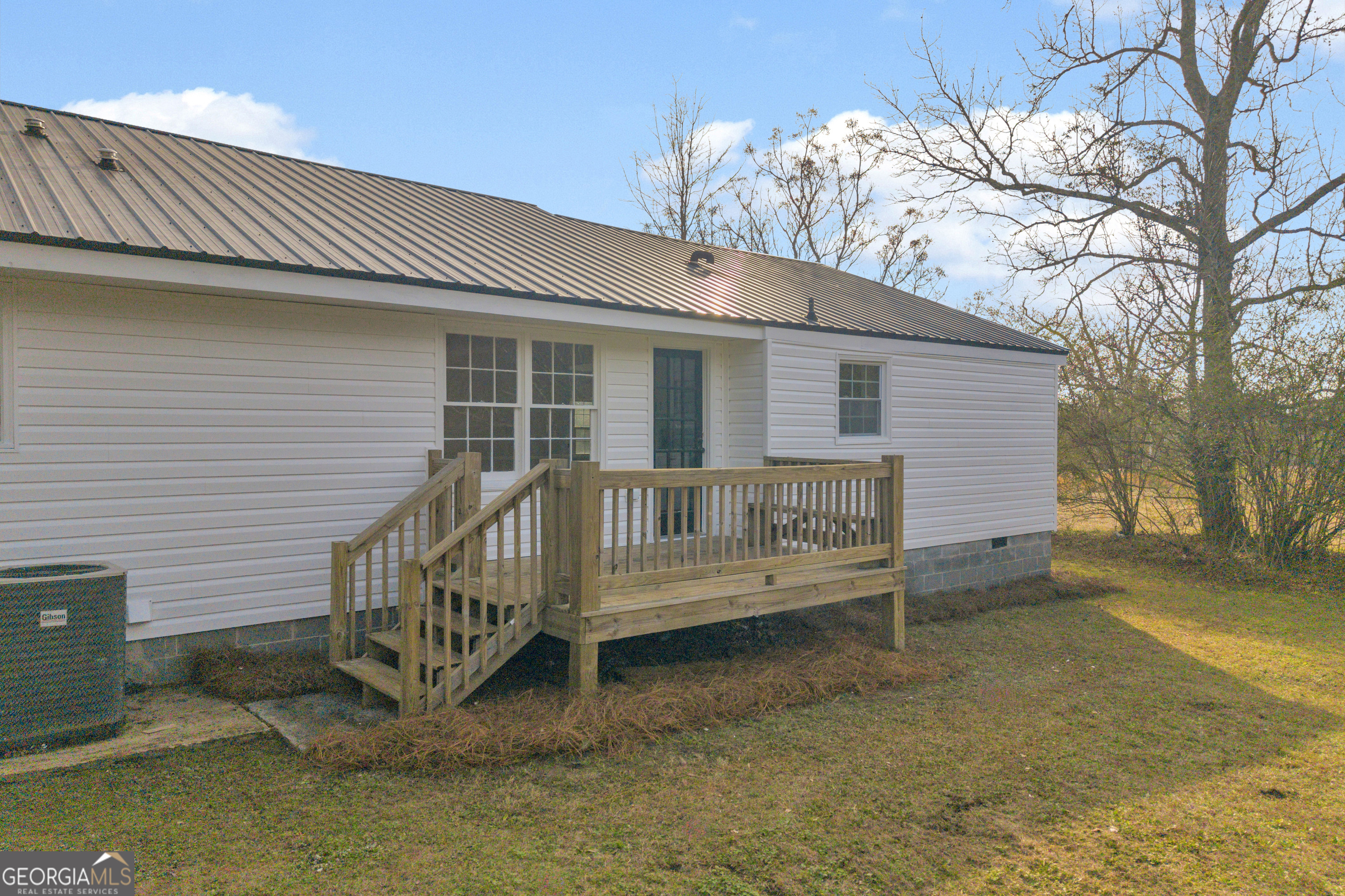 1160 Planing Mill Road Greensboro, GA 30642 - Photo 12 of 76 a view of a house with a wooden deck and a yard