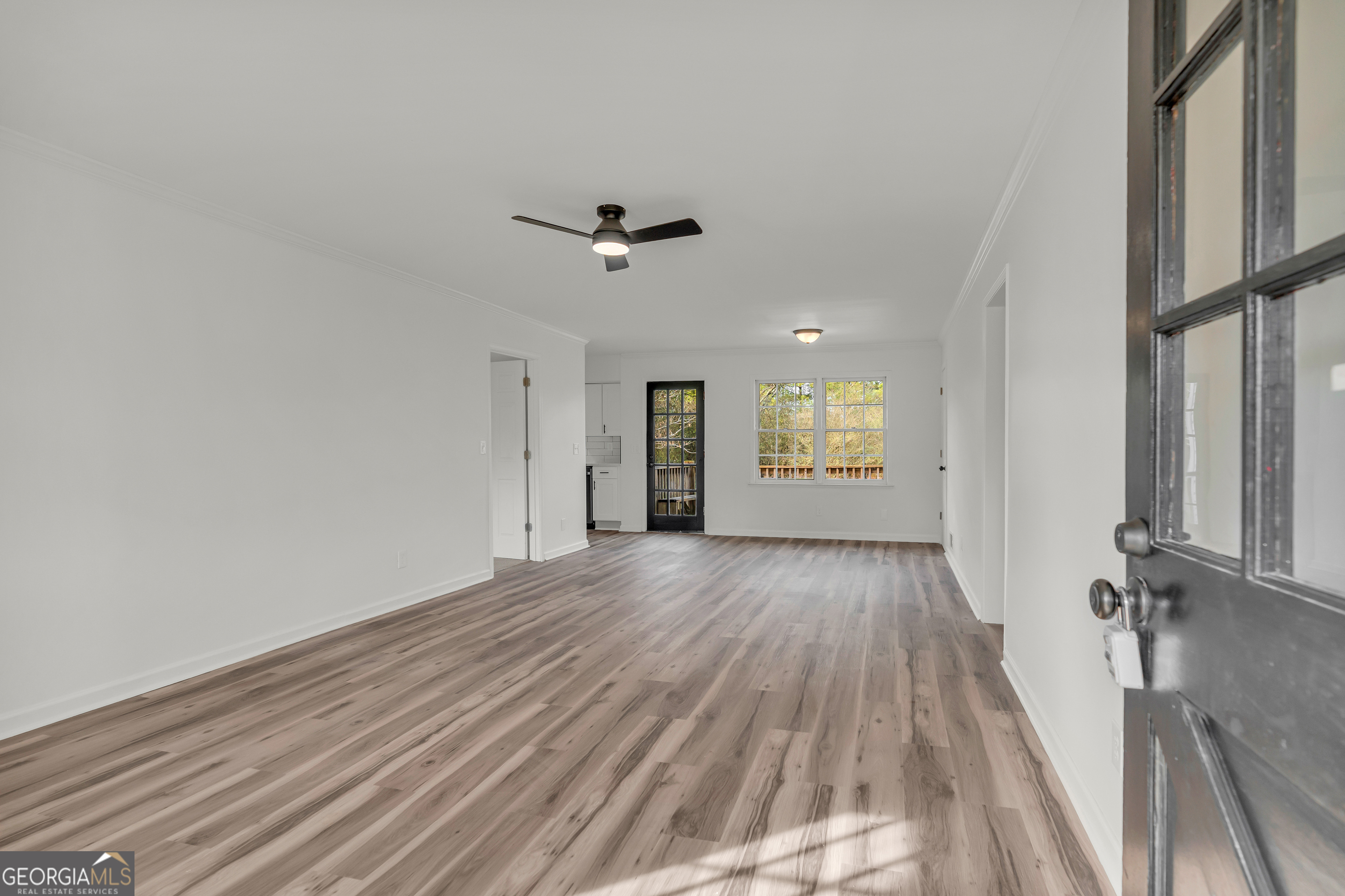 1160 Planing Mill Road Greensboro, GA 30642 - Photo 23 of 76 a view of an empty room with a window and wooden floor