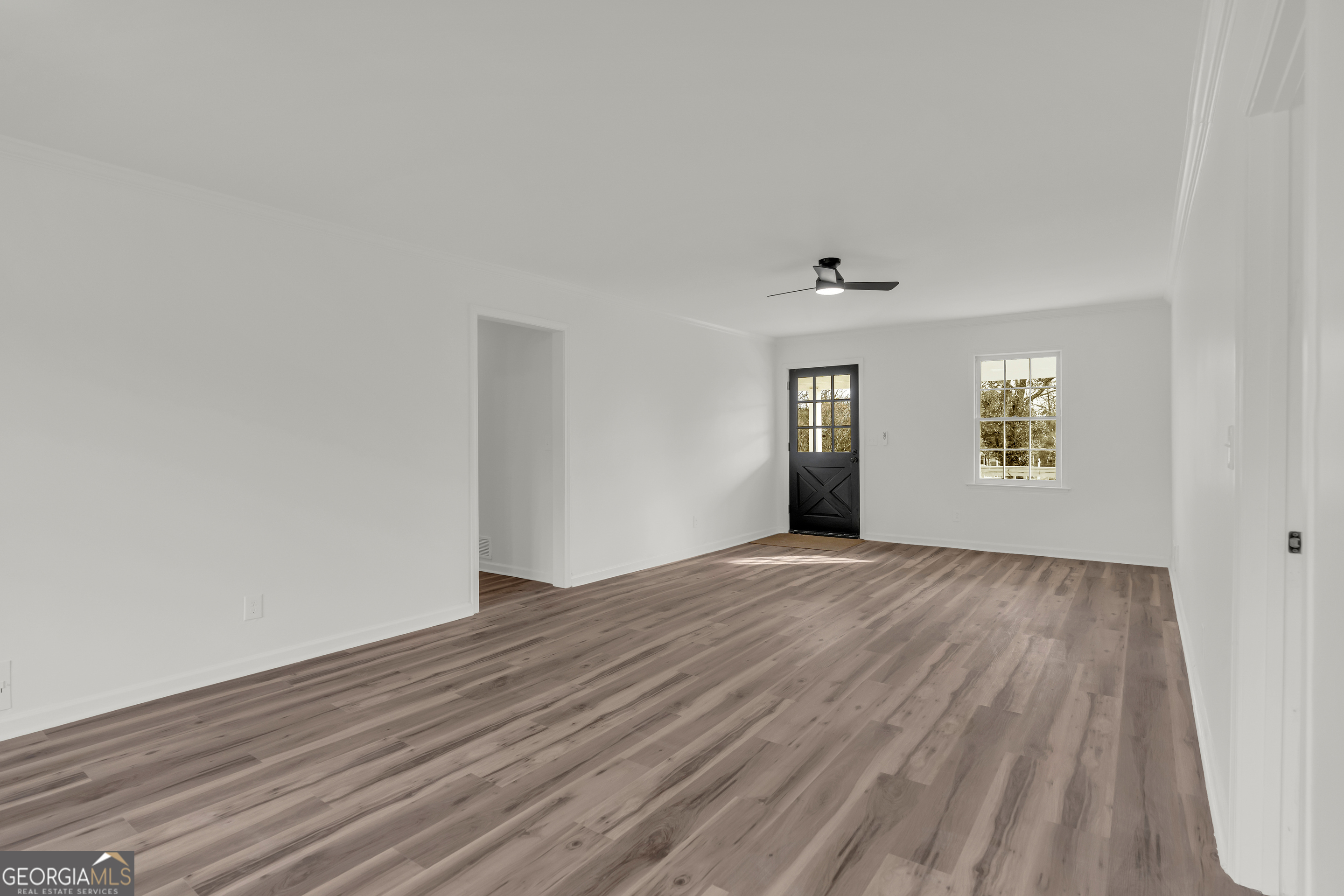 1160 Planing Mill Road Greensboro, GA 30642 - Photo 26 of 76 a view of an empty room with wooden floor and a window