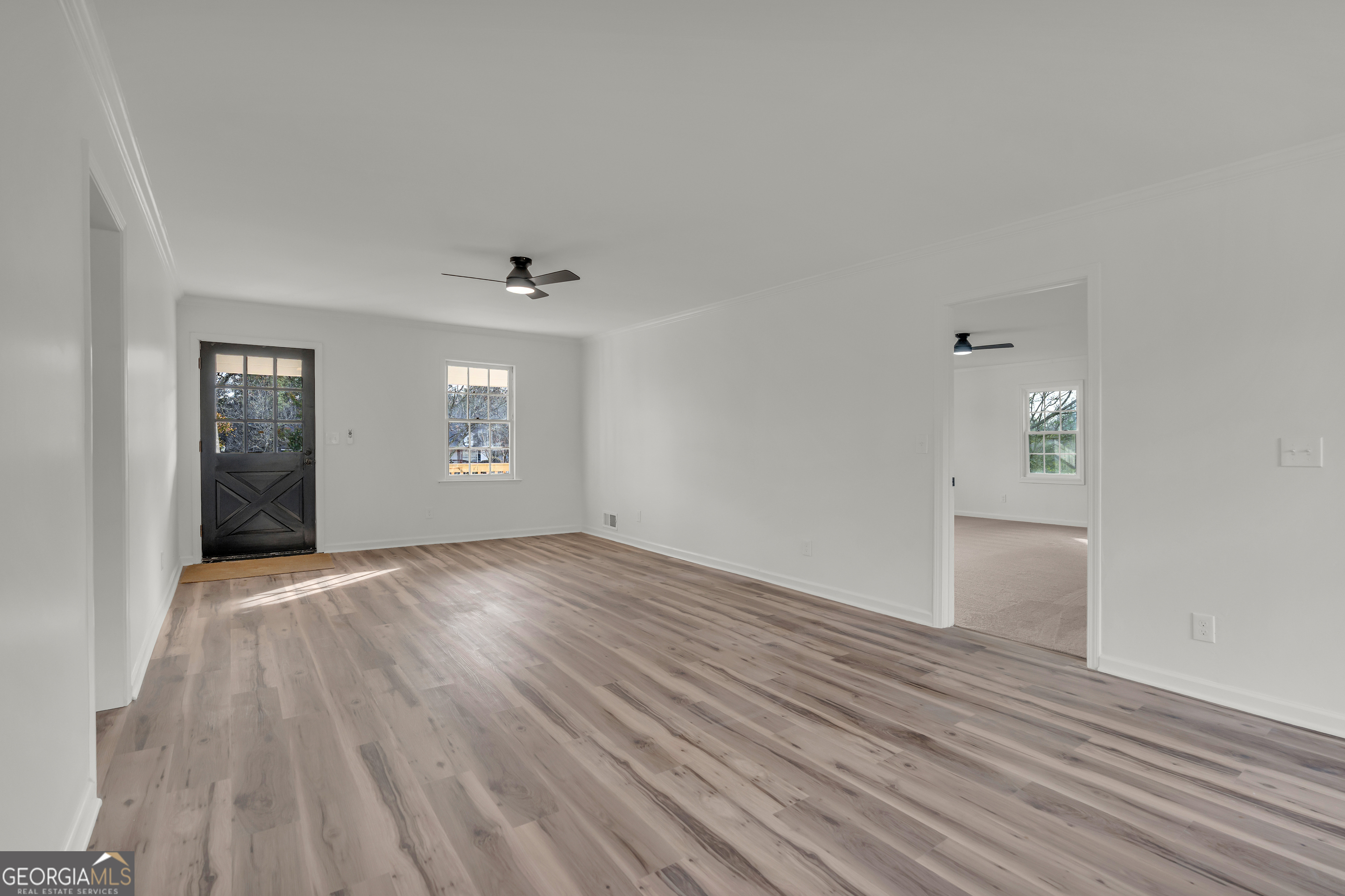 1160 Planing Mill Road Greensboro, GA 30642 - Photo 27 of 76 an empty room with wooden floor and windows