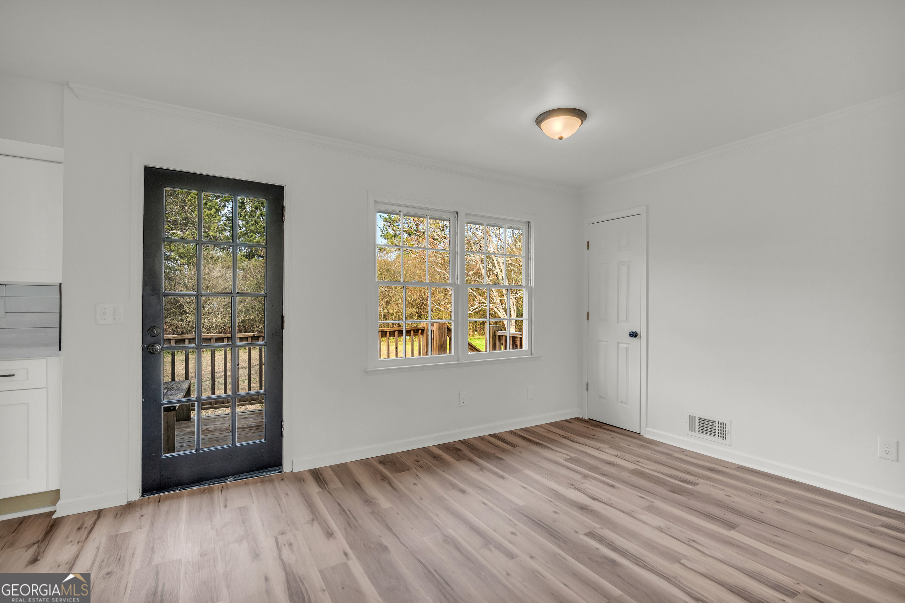 1160 Planing Mill Road Greensboro, GA 30642 - Photo 29 of 76 a view of an empty room with wooden floor and a window
