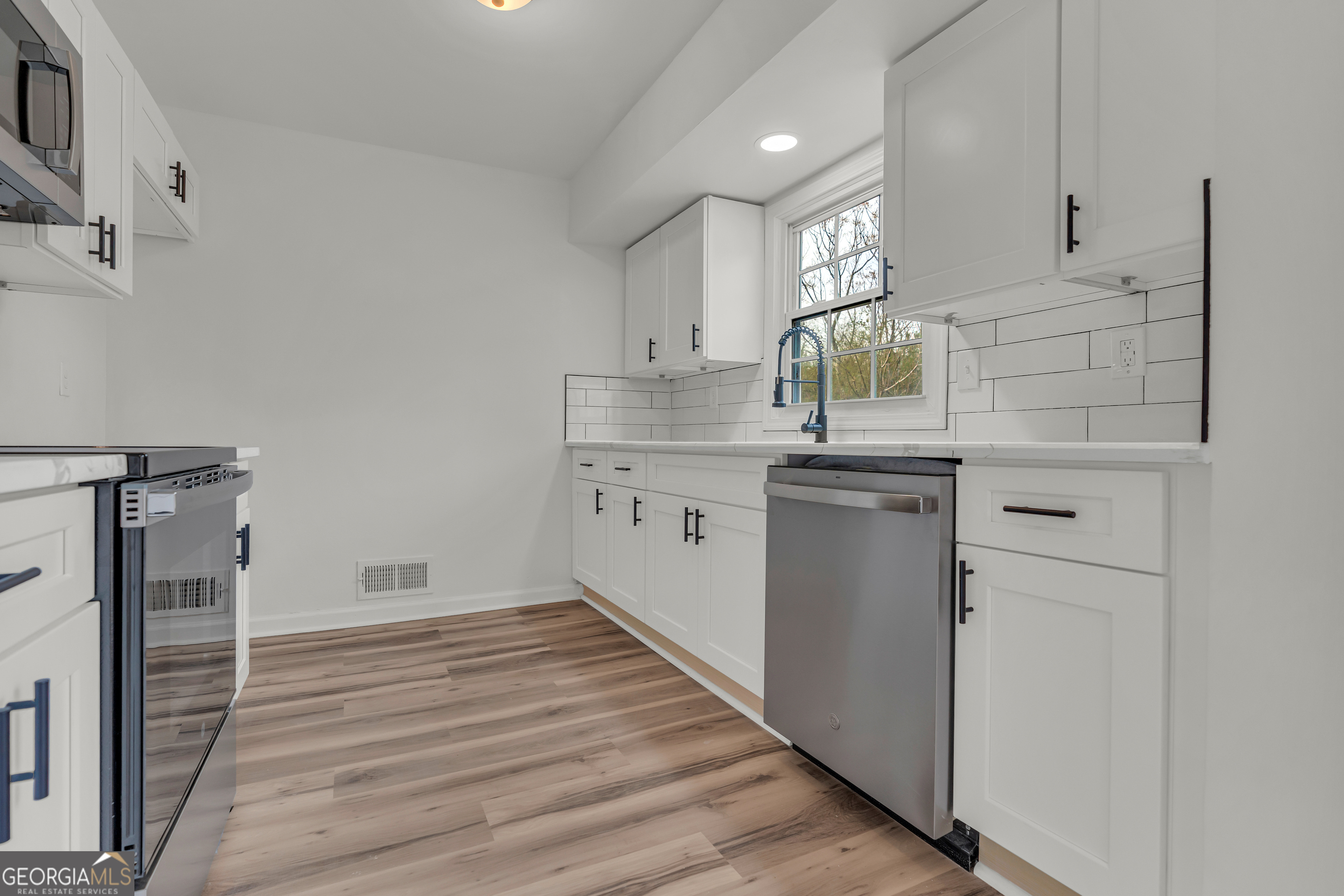 1160 Planing Mill Road Greensboro, GA 30642 - Photo 38 of 76 a kitchen with white cabinets and sink
