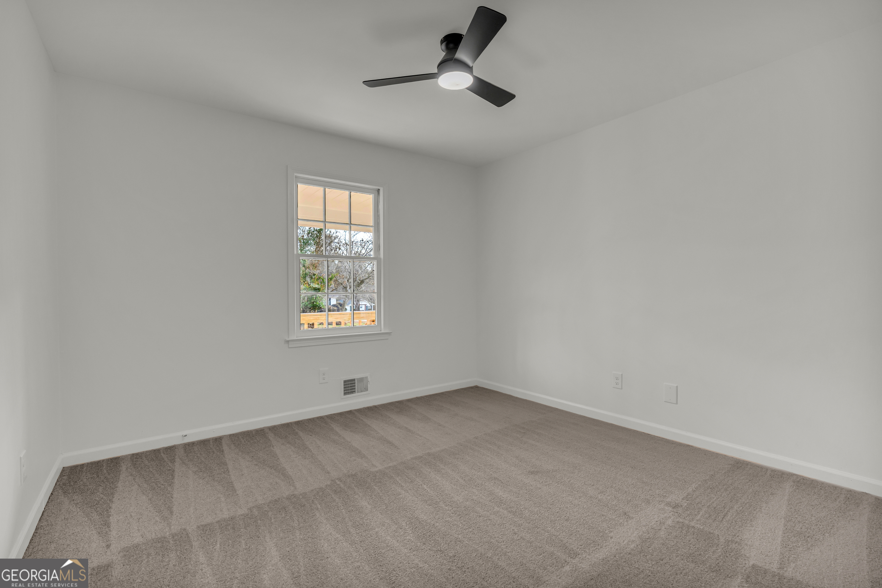 1160 Planing Mill Road Greensboro, GA 30642 - Photo 48 of 76 an empty room with a window and a ceiling fan