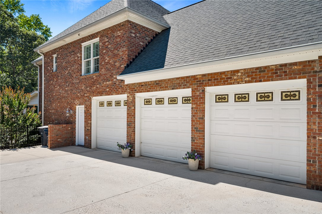 200 Graylyn Drive Anderson, SC 29621 - Photo 44 of 48 A spacious three-car garage provides ample vehicle storage with direct access to the brick-clad home.