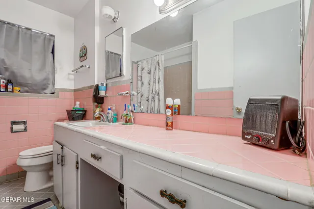 a bathroom with a sink a toilet and a large mirror