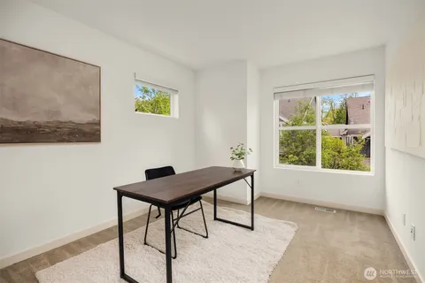 a view of a workspace with furniture and a window