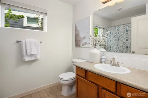 a bathroom with a granite countertop sink toilet and mirror