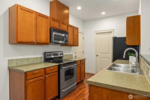 a kitchen with stainless steel appliances granite countertop a sink a stove and a microwave