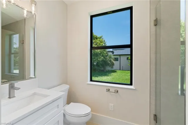 a bathroom with a toilet a sink a vanity and mirror