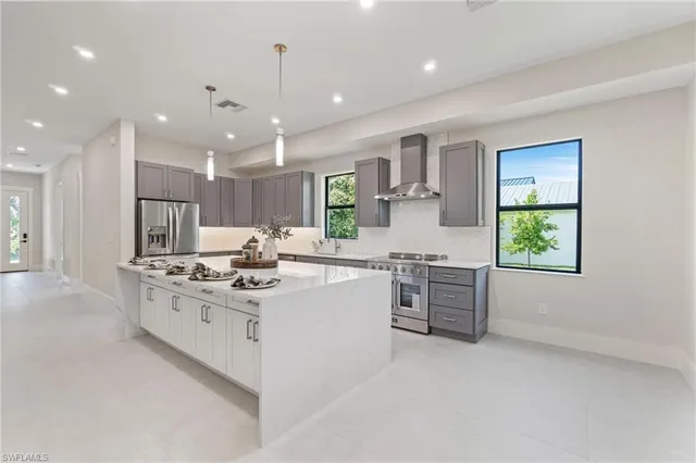a kitchen with kitchen island granite countertop a sink stove and cabinets