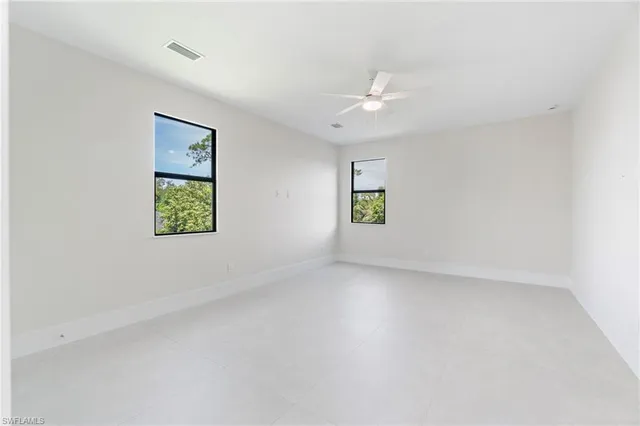an empty room with a window and a ceiling fan