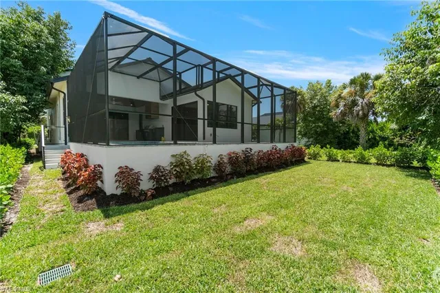 a front view of a house with a yard and trees