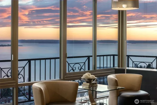 a kitchen with stainless steel appliances granite countertop a stove a refrigerator a dining table and chairs with wooden floor