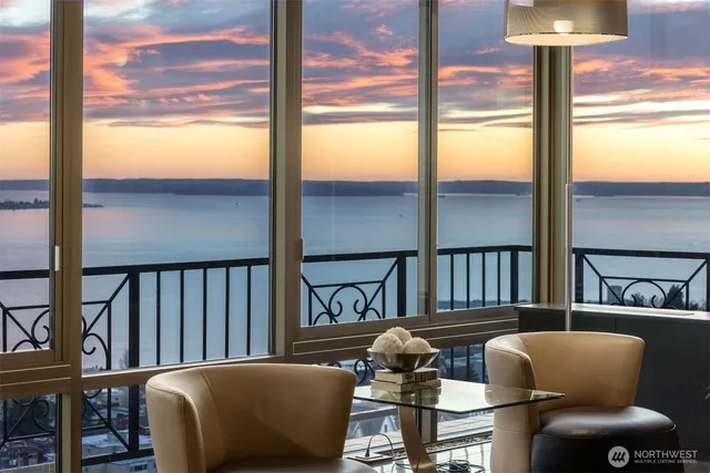 a kitchen with stainless steel appliances granite countertop a stove a refrigerator a dining table and chairs with wooden floor