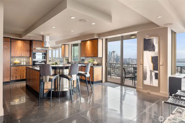 a kitchen with stainless steel appliances granite countertop a stove and a view of living room