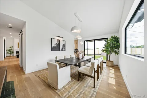 a living room with furniture a large window and potted plants