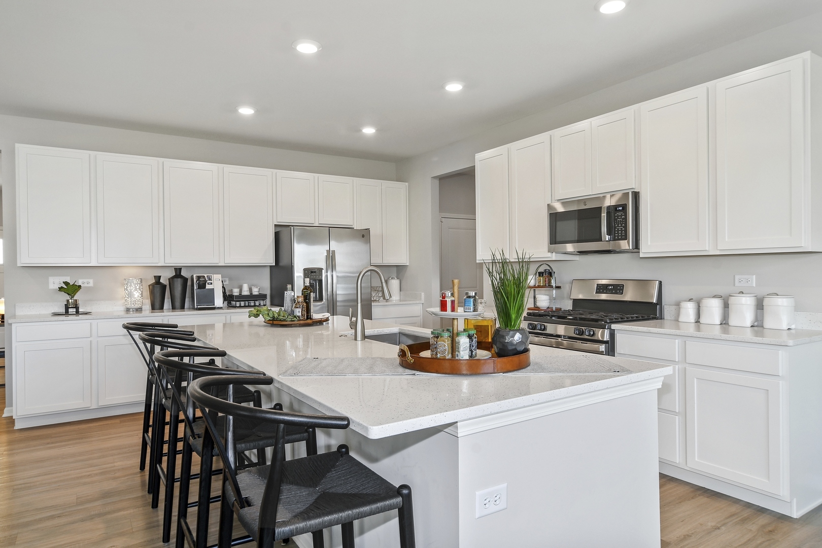 16249 Longcommon Lane Plainfield, IL 60586 - Photo 2 of 27 a kitchen with a table chairs microwave and cabinets