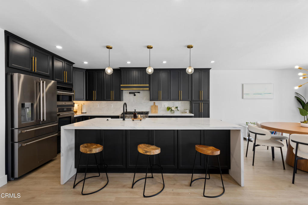 3960 West Hemlock Street Oxnard, CA 93035 - Photo 11 of 42 a kitchen with stainless steel appliances a dining table and chairs