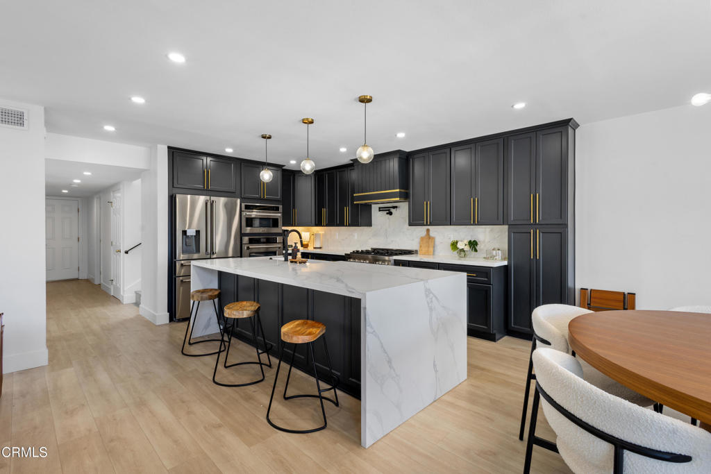 3960 West Hemlock Street Oxnard, CA 93035 - Photo 14 of 42 a kitchen that has a table chairs and refrigerator