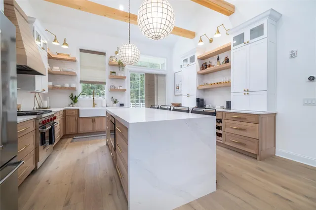 a kitchen with kitchen island a sink a counter top space and stainless steel appliances
