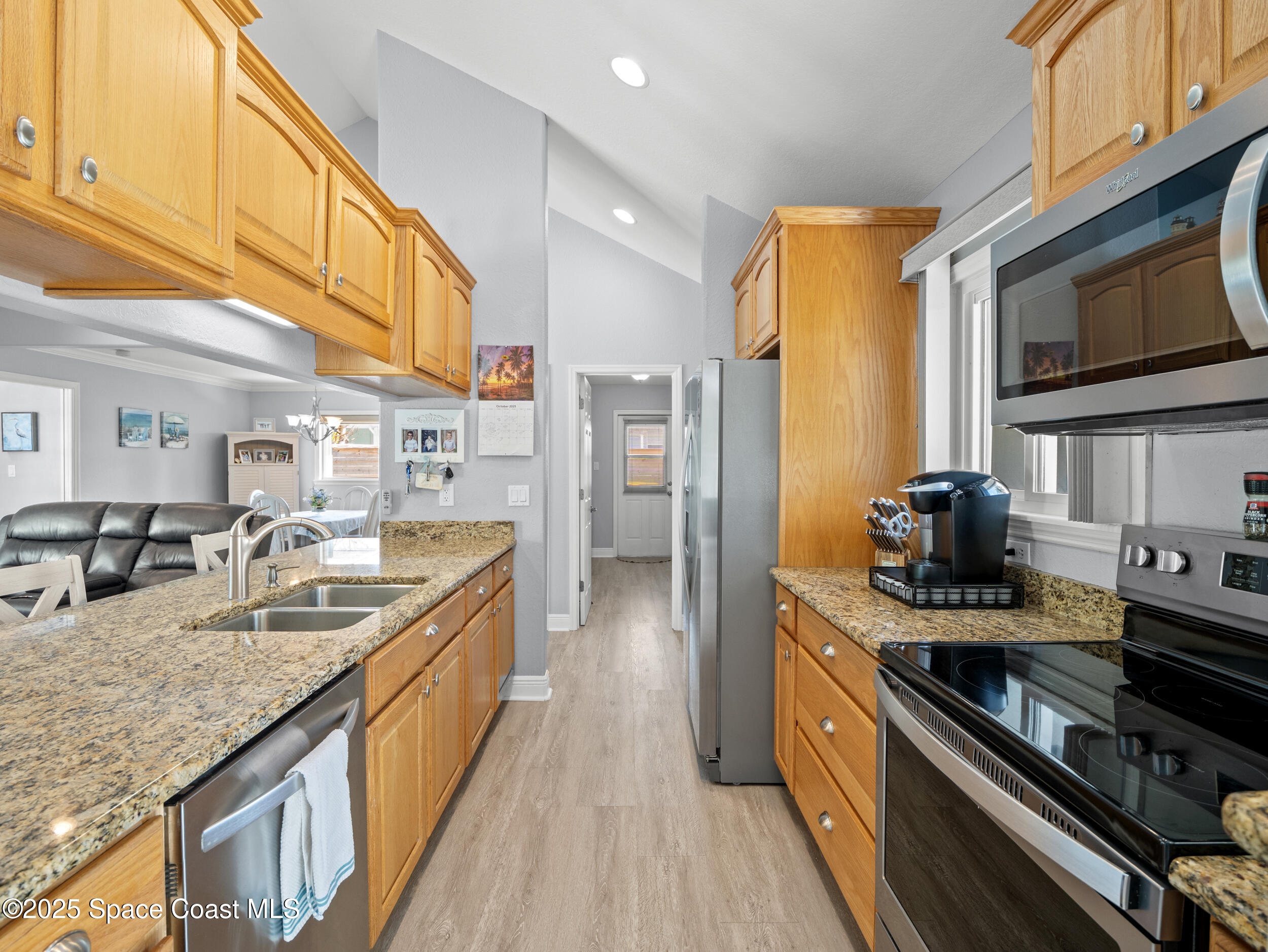 230 Riggs Avenue Melbourne Beach, FL 32951 - Photo 11 of 38 a kitchen with stainless steel appliances granite countertop a sink stove and refrigerator