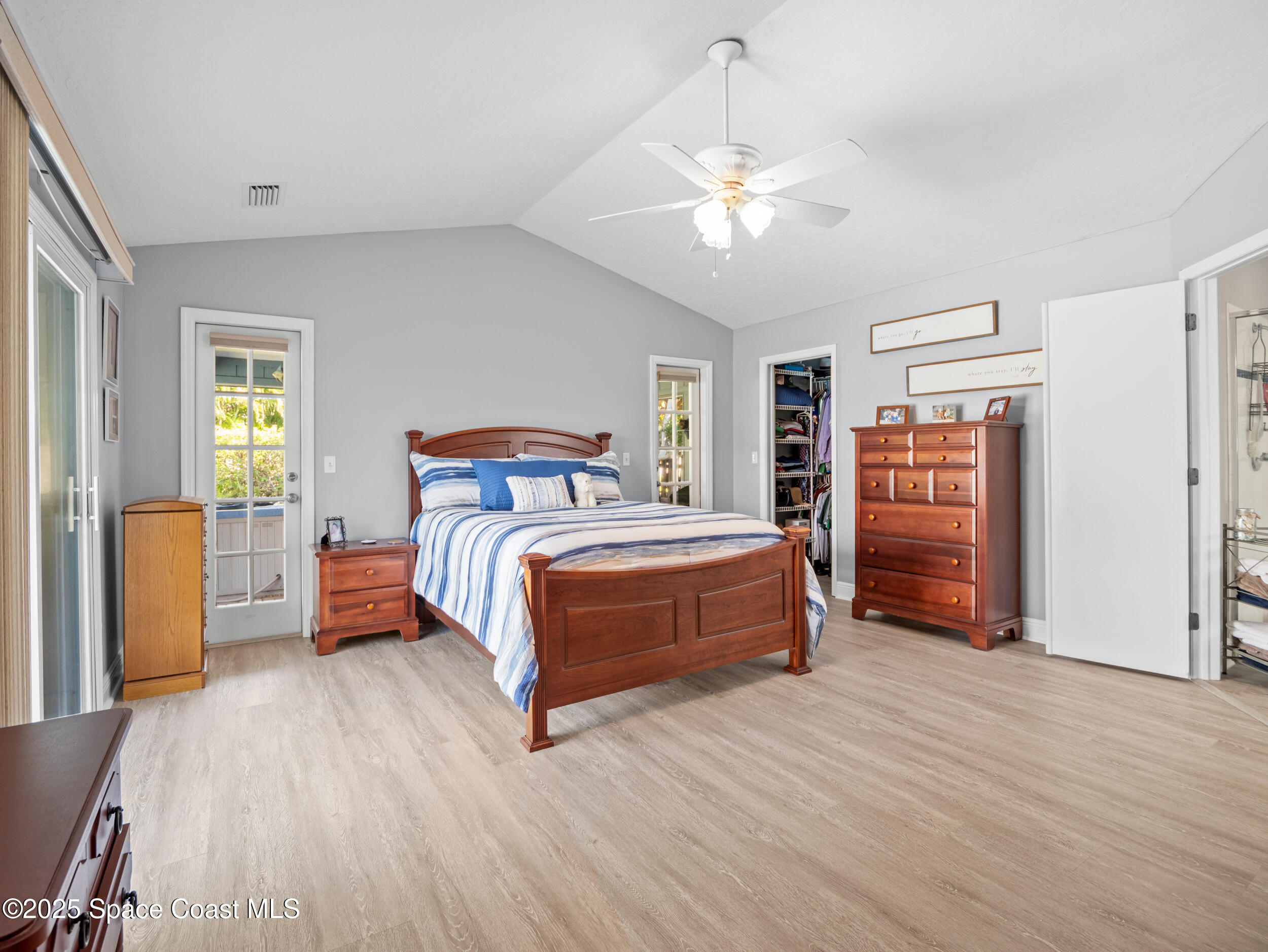 230 Riggs Avenue Melbourne Beach, FL 32951 - Photo 13 of 38 a bedroom with a large bed a chandelier and closet