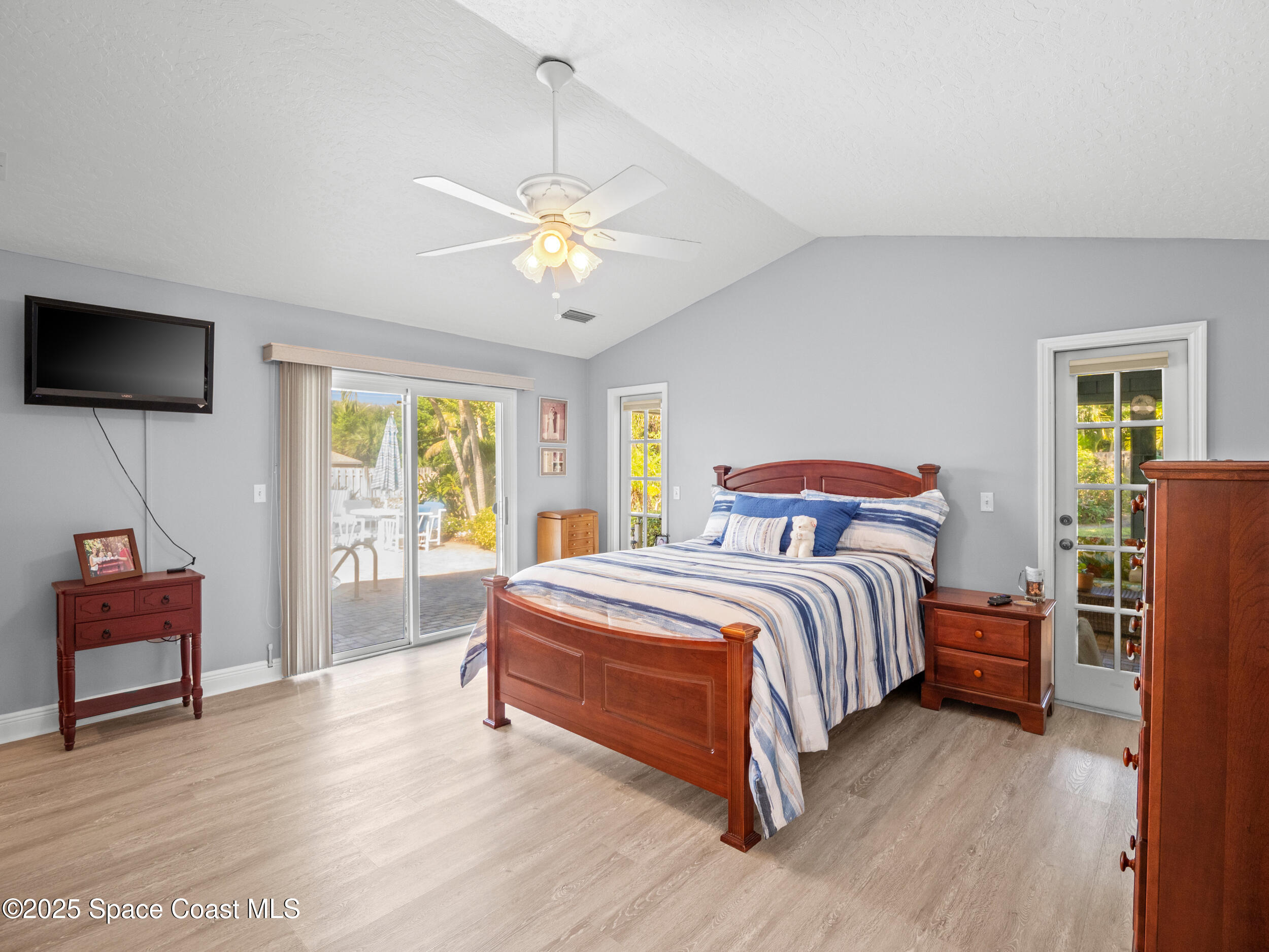 230 Riggs Avenue Melbourne Beach, FL 32951 - Photo 14 of 38 a spacious bedroom with a bed and a flat screen tv