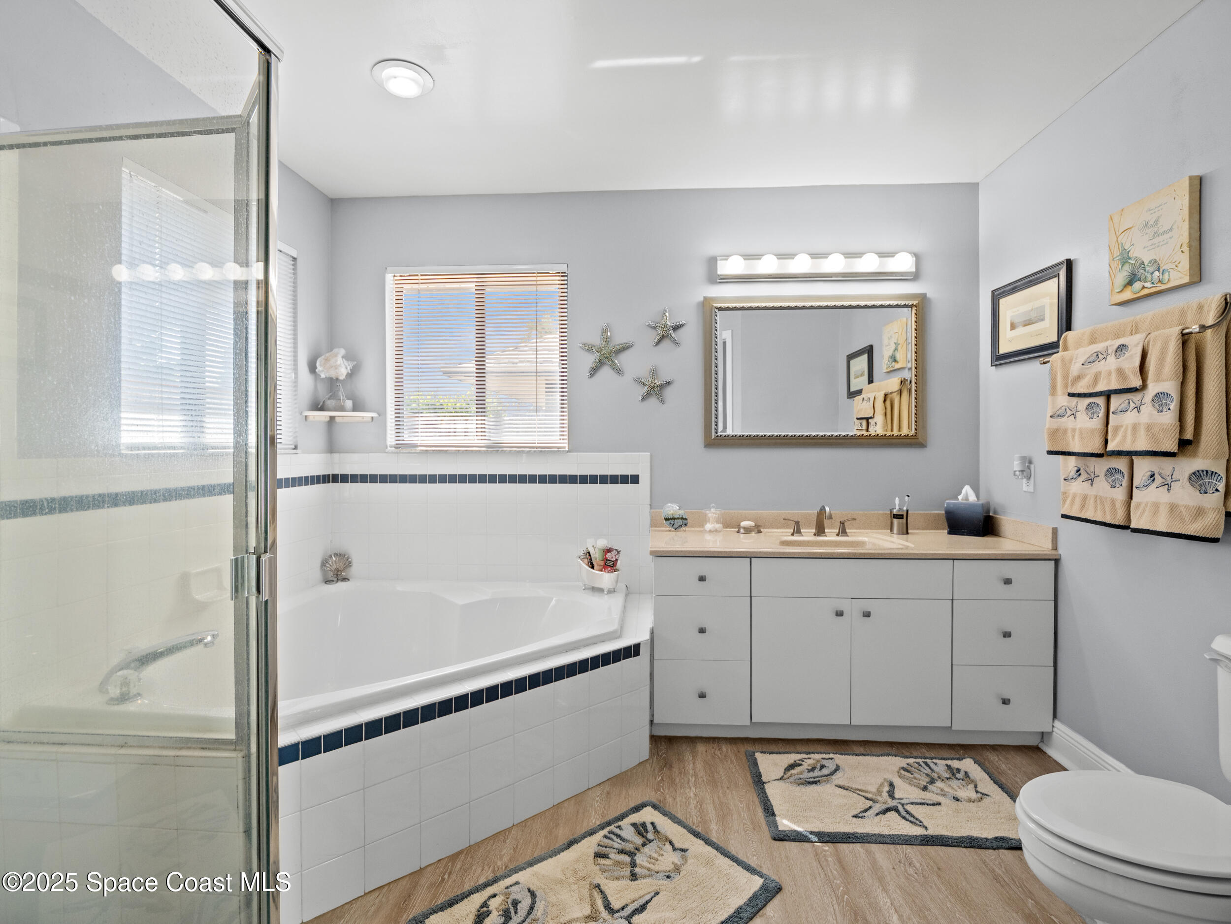 230 Riggs Avenue Melbourne Beach, FL 32951 - Photo 16 of 38 a bathroom with a bathtub sink mirror vanity and toilet