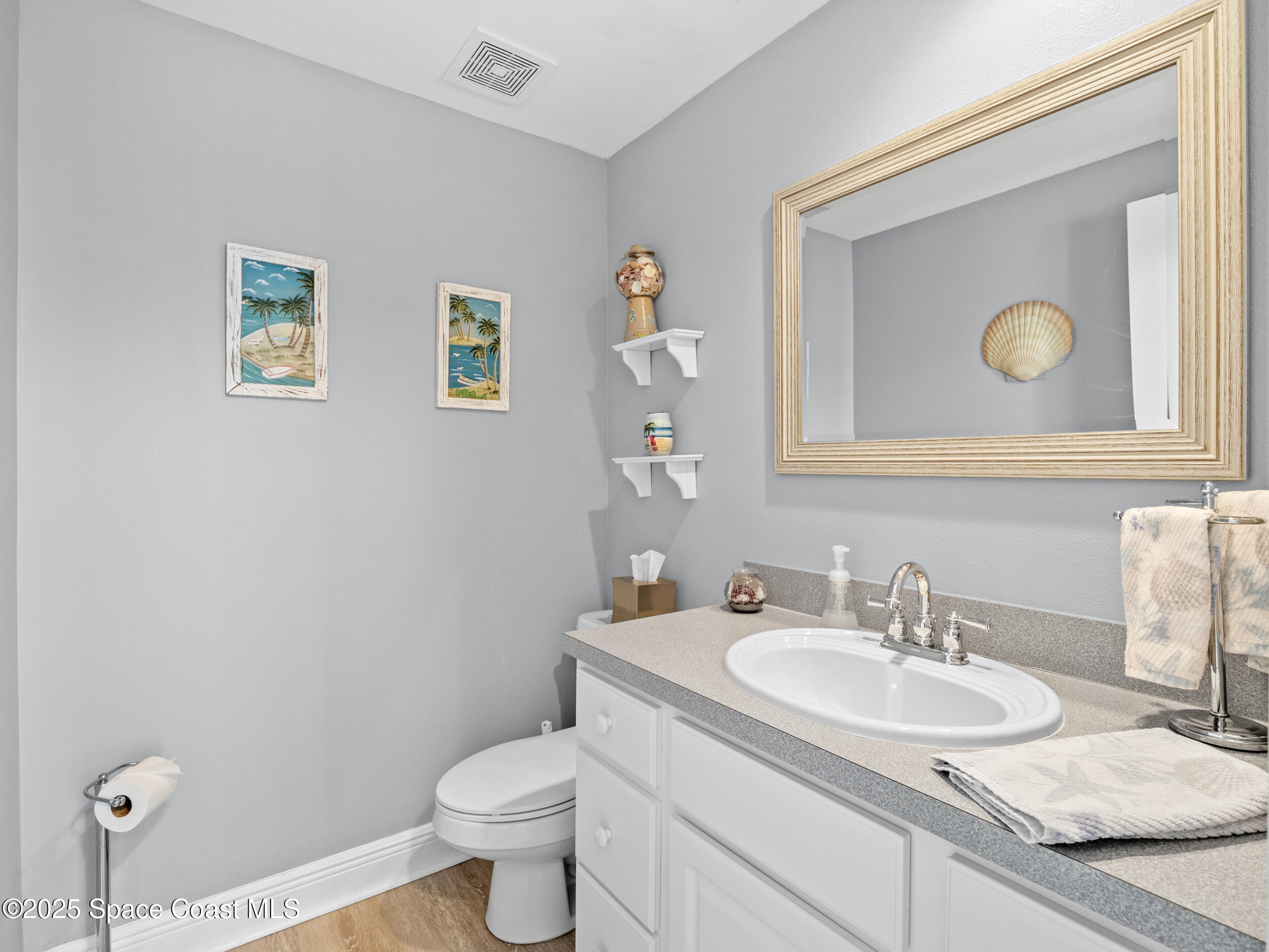230 Riggs Avenue Melbourne Beach, FL 32951 - Photo 21 of 38 a bathroom with a granite countertop toilet sink and mirror