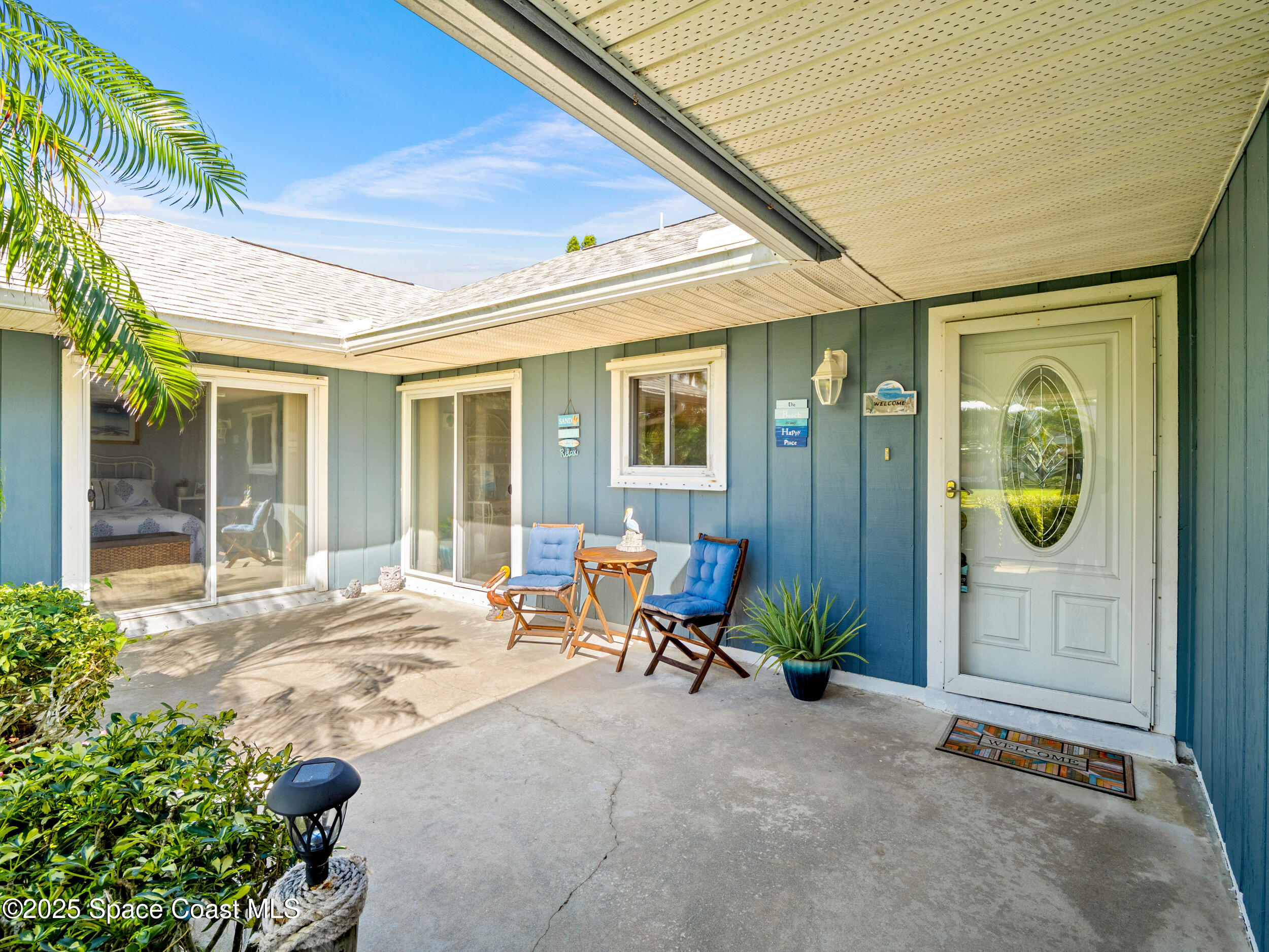 230 Riggs Avenue Melbourne Beach, FL 32951 - Photo 3 of 38 a view of a chair and table in front of house