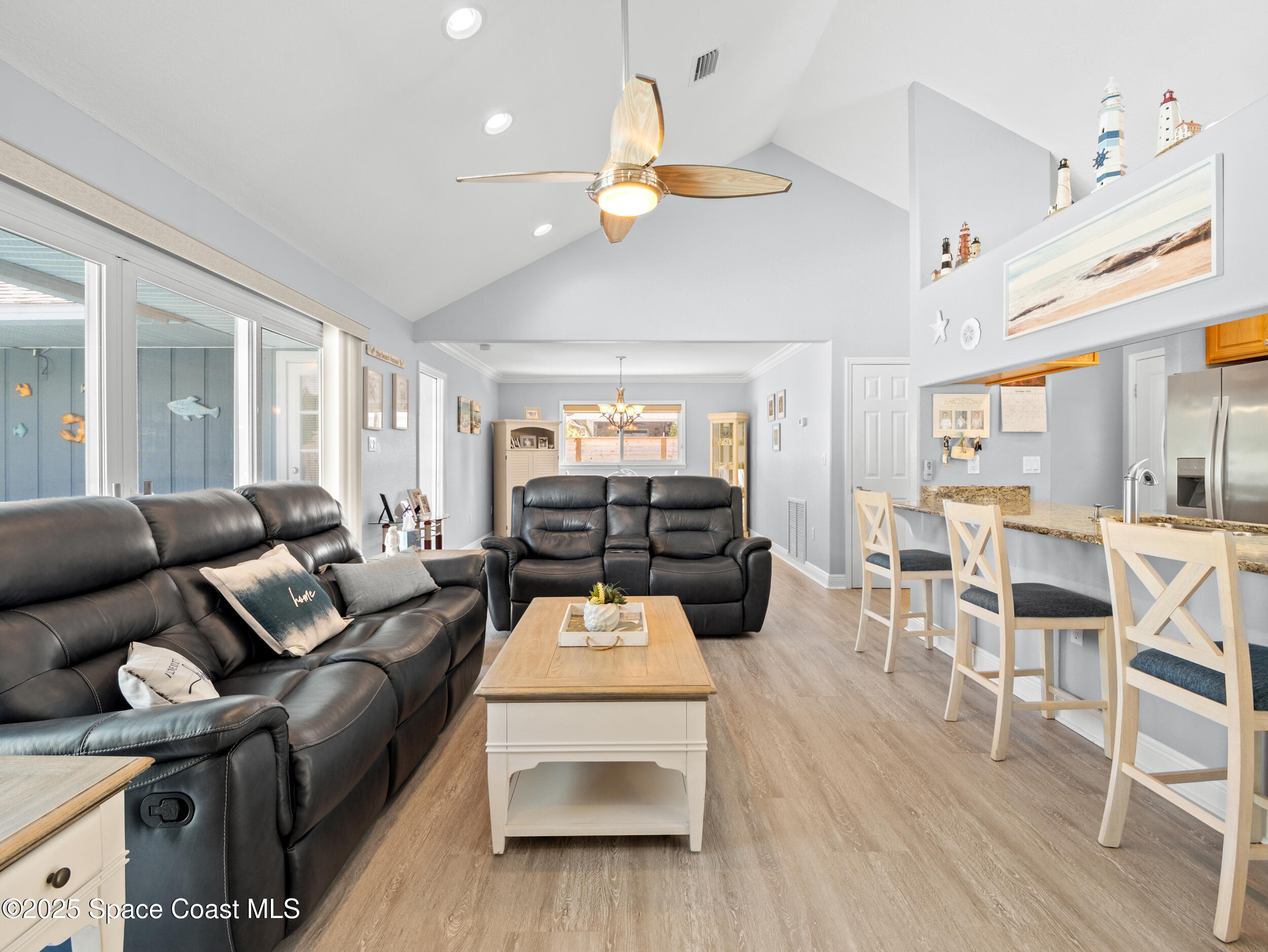 230 Riggs Avenue Melbourne Beach, FL 32951 - Photo 7 of 38 a living room with furniture a chandelier and a dining table