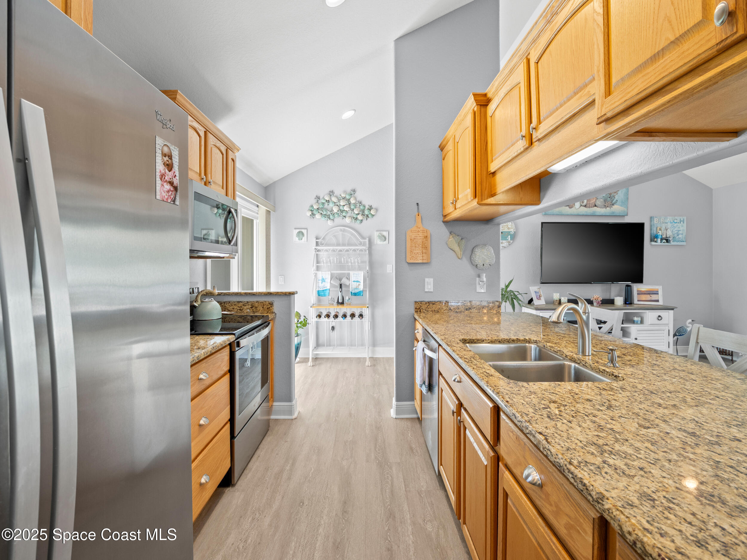 230 Riggs Avenue Melbourne Beach, FL 32951 - Photo 10 of 38 a kitchen with stainless steel appliances granite countertop a sink stove and refrigerator
